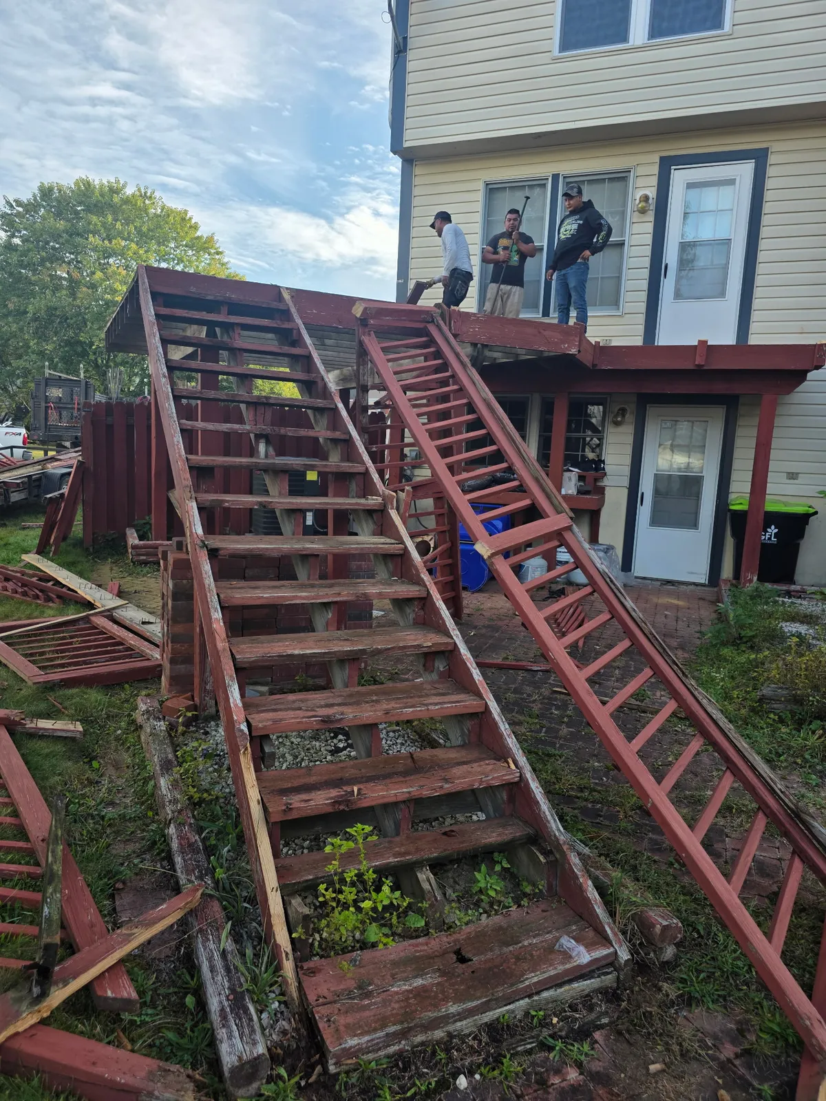TWO MEN crew performing outdoor demolition and removal work