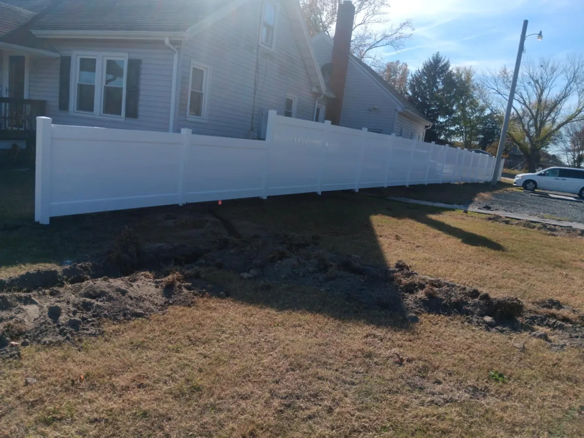 White vinyl privacy fence installation alongside Delaware home