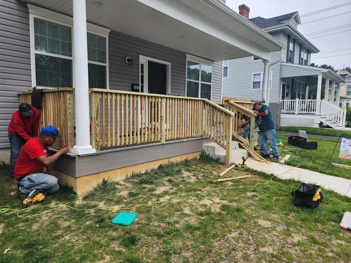 TWO MEN crew installing custom wood porch railing on Delaware home