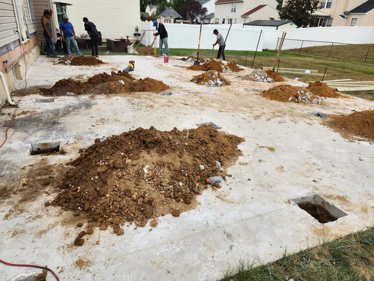 Crew setting post holes for fence installation