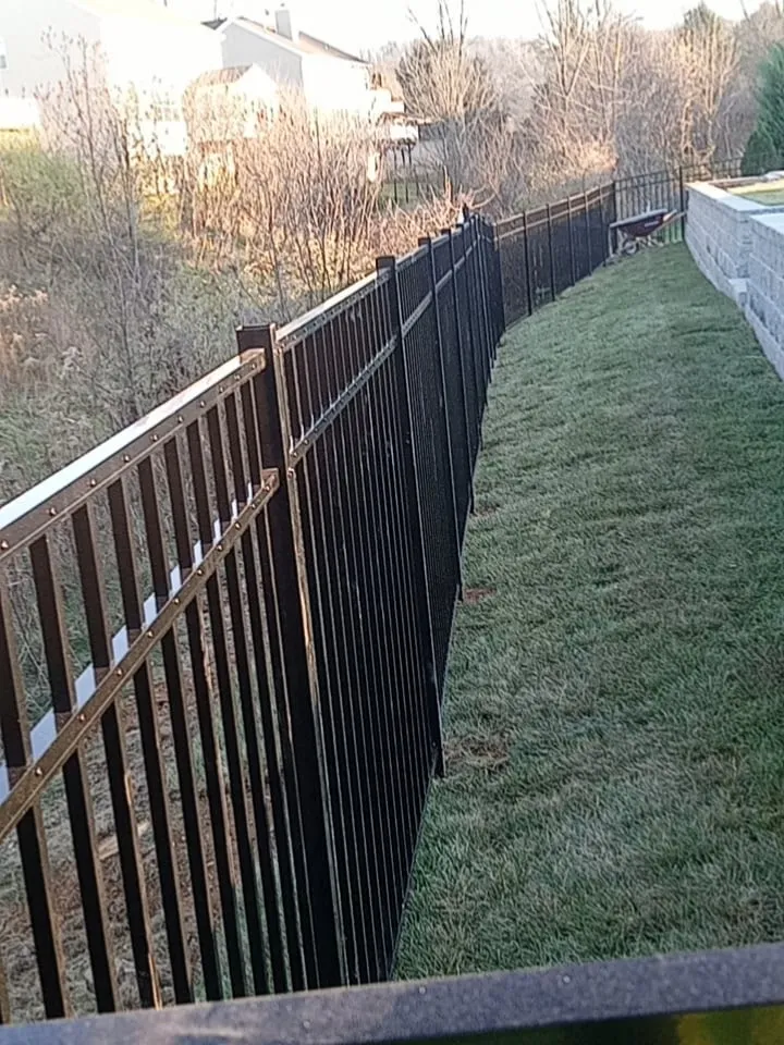 Black aluminum ornamental fence along sloped residential yard