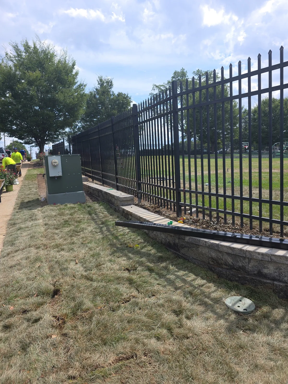 Black aluminum ornamental fence on retaining wall at commercial property